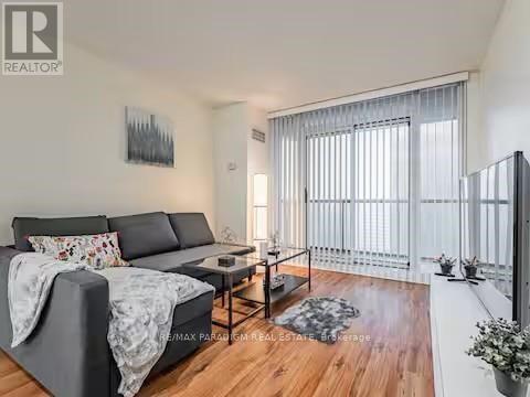 A living room with a grey sofa and a wooden floor.