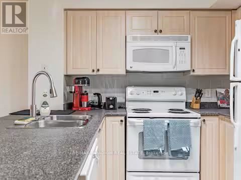 A kitchen with a white oven and a white microwave.