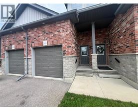 A house with a grey garage door and a black door.