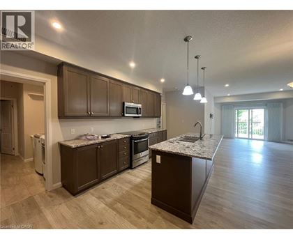 A modern kitchen with brown cabinets and a granite countertop.