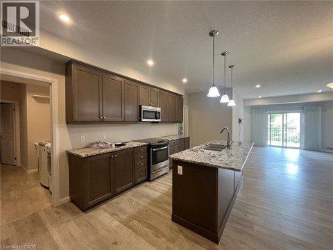 A modern kitchen with brown cabinets and a granite countertop.