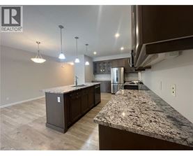 A kitchen with granite countertops and wooden floors.