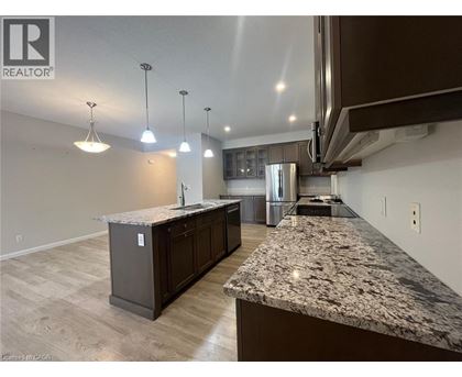A kitchen with granite countertops and wooden floors.
