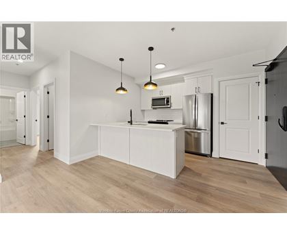 A kitchen with white cabinets and a wooden floor.