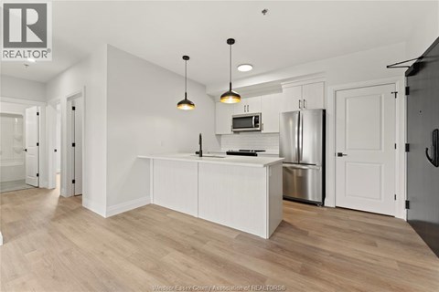 A kitchen with white cabinets and a wooden floor.