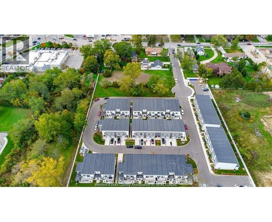 An aerial view of a large building surrounded by trees and a parking lot.