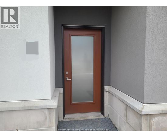 A brown door with a glass panel is set in a white wall.