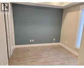 A room with a grey wall and wooden flooring.
