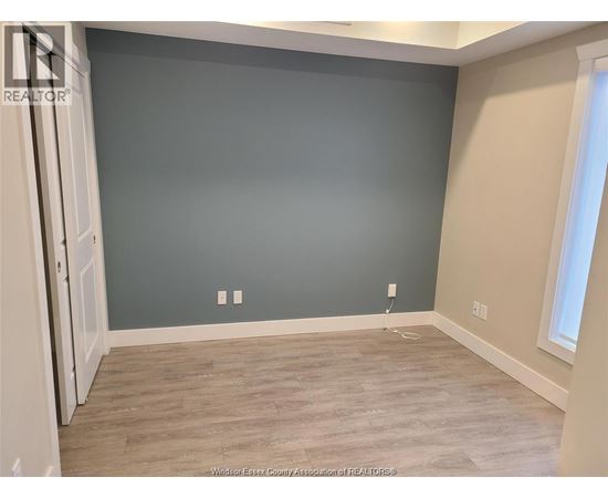 A room with a grey wall and wooden flooring.