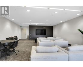 A conference room with a large table, chairs, and a television.