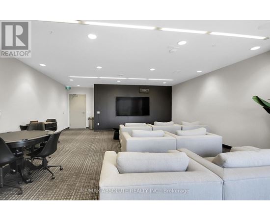 A conference room with a large table, chairs, and a television.