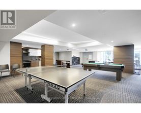 A ping pong table is in the middle of a room with a pool table.