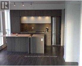 A modern kitchen with a large island and stainless steel appliances.