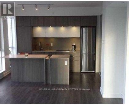 A modern kitchen with a large island and stainless steel appliances.