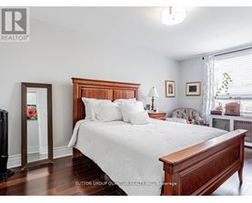 A bedroom with a large bed and a window with blinds.
