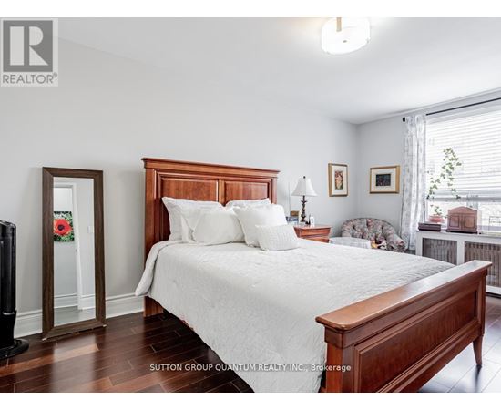 A bedroom with a large bed and a window with blinds.
