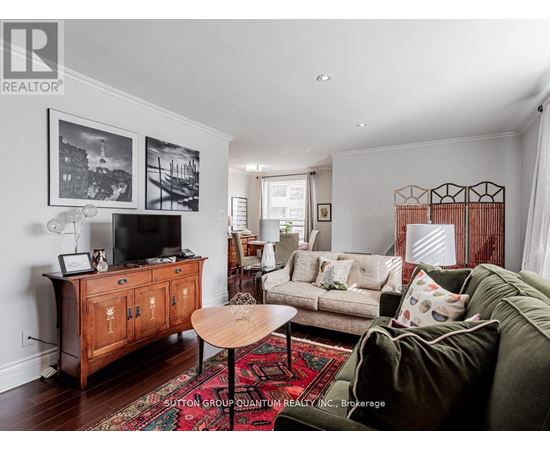A living room with a green couch and a wooden cabinet.