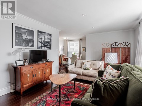 A living room with a green couch and a wooden cabinet.