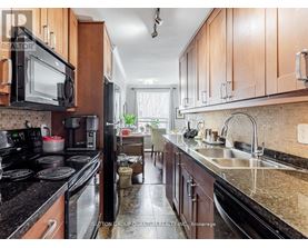 A kitchen with wooden cabinets and black appliances.