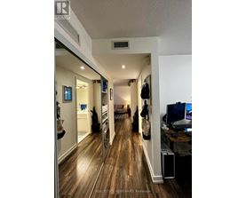 A hallway with wood floors and a white ceiling.