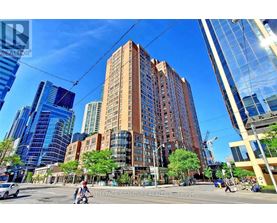 A tall building with a brown facade stands in the middle of a city street.