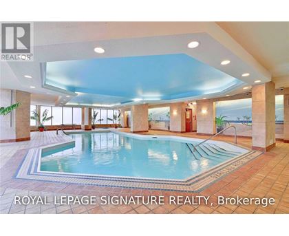 A large indoor swimming pool with a tiled floor and a glass ceiling.