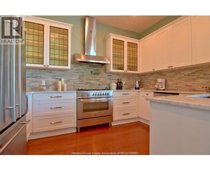 A kitchen with white cabinets and a stainless steel refrigerator.