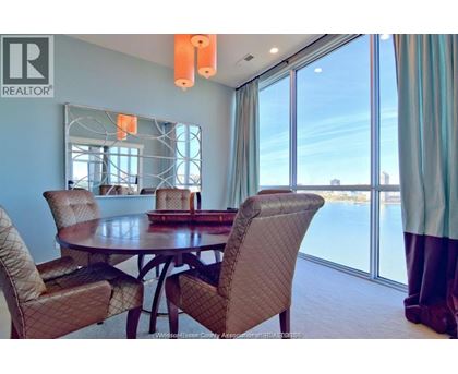 A dining room with a table and chairs.