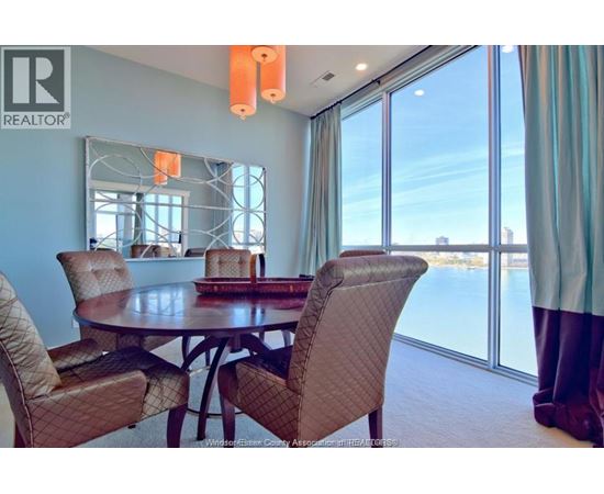 A dining room with a table and chairs.