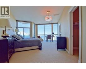 A bedroom with a large bed and a view of the city.