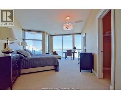 A bedroom with a large bed and a view of the city.