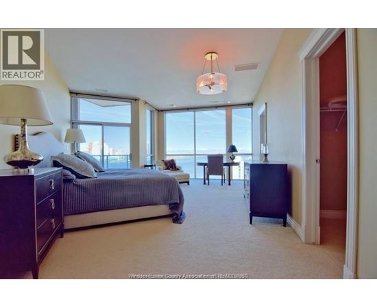 A bedroom with a large bed and a view of the city.