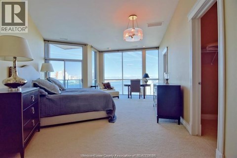 A bedroom with a large bed and a view of the city.