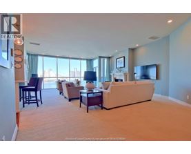 A living room with a couch, chairs, and a television.