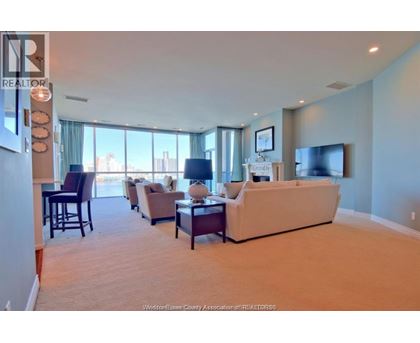 A living room with a couch, chairs, and a television.