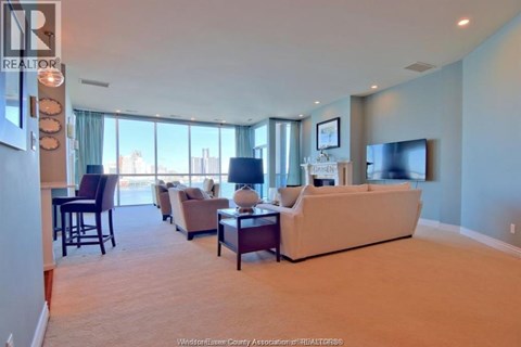 A living room with a couch, chairs, and a television.