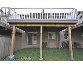 A wooden deck over a house with a white railing.