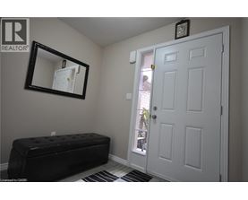 A white door is in a room with a black bench and a mirror.