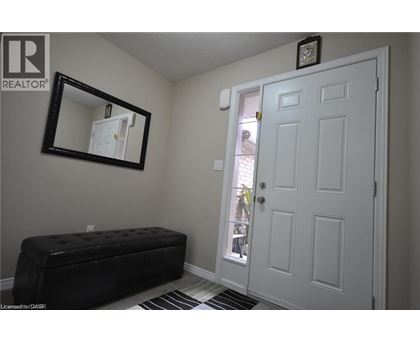 A white door is in a room with a black bench and a mirror.
