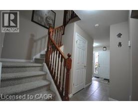 A hallway with a staircase and a door.