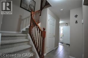 A hallway with a staircase and a door.