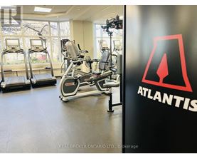 A gym with treadmills, elliptical machines and a wall with the word Atlantis on it.