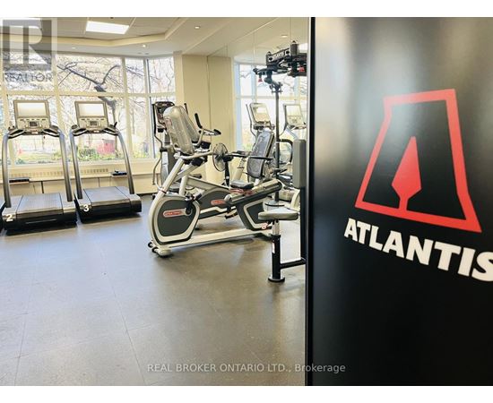 A gym with treadmills, elliptical machines and a wall with the word Atlantis on it.