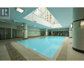 A large indoor swimming pool with the words "Royal LePage Signature Realty Brokerage" on the floor.