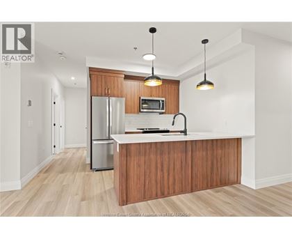 A kitchen with wooden cabinets and a refrigerator.