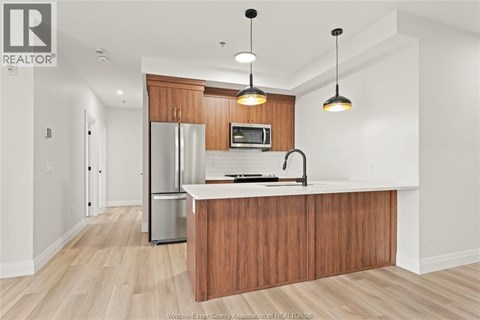A kitchen with wooden cabinets and a refrigerator.