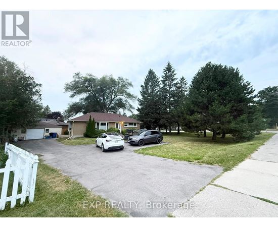 A white picket fence marks the entrance to a residential driveway.