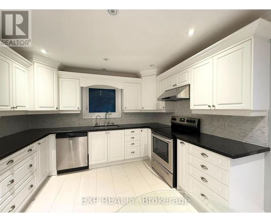 A kitchen with white cabinets and black countertops.
