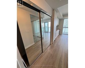 A room with a sliding glass door and wooden flooring.