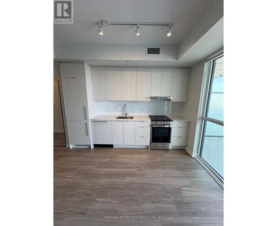 A modern kitchen with white cabinets and a stainless steel stove.